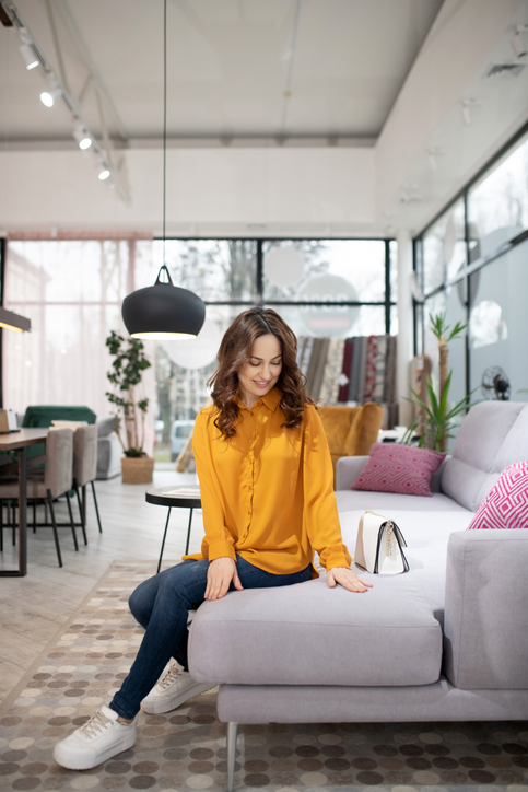 Long-haired pretty woman sitting on the cosy sofa